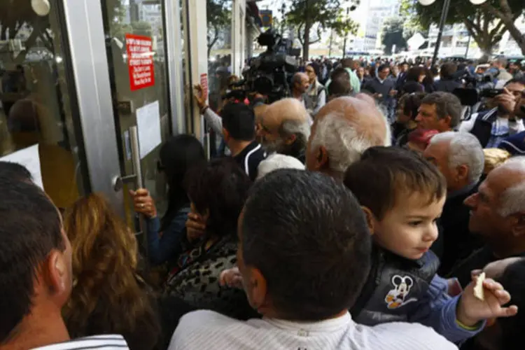 
	Aglomera&ccedil;&atilde;o em frente a banco no Chipre esperando a abertura de uma ag&ecirc;ncia banc&aacute;ria: gregos e cipriotas s&atilde;o os que t&ecirc;m menos f&eacute; na institui&ccedil;&atilde;o
 (Reuters)