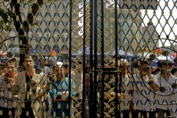 
	Mu&ccedil;ulmanos tentam entrar em mesquita em Xinjiang, na China, regi&atilde;o conhecida pelos conflitos &eacute;tnicos: segundo o tribunal, os acusados participavam de&nbsp;&quot;atividades religiosas ilegais&quot;
 (Nelson Ching/Bloomberg News)
