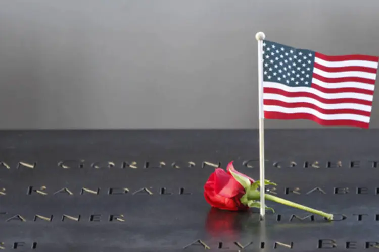 
	Uma flor e uma bandeira americana s&atilde;o colocados no lado dos nomes inscritos no memorial do 11 de setembro
 (Mary Altaffer-Pool/Getty Images)