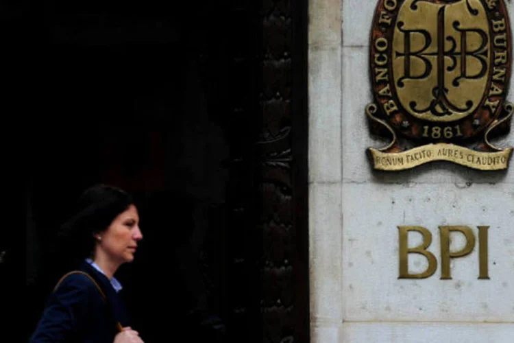 Mulher caminha em frente a um escritório do Banco BPI de Portugal, em Lisboa (Jasper Juinen / Getty Images)