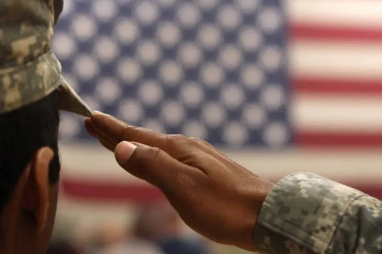 
	Soldado sa&uacute;da a bandeira dos EUA durante cerim&ocirc;nia para o retorno das tropas do Afeganist&atilde;o, em Fort Carson, Colorado
 (John Moore/Getty Images)