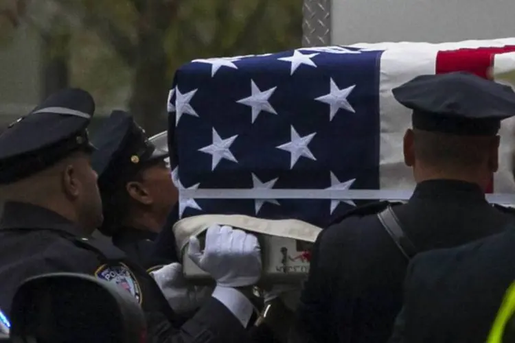 Oficiais carregam caixas metálicas envolvidas pela bandeira americana durante a transferência dos restos mortais de vítimas não identificados do 9/11 (Reuters/Eric Thayer)