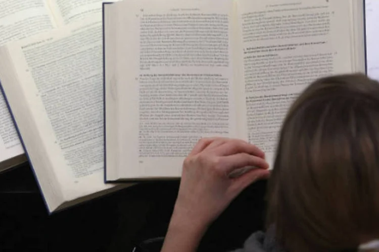 Estudante lê livros em universidade (Adam Berry/Getty Images)