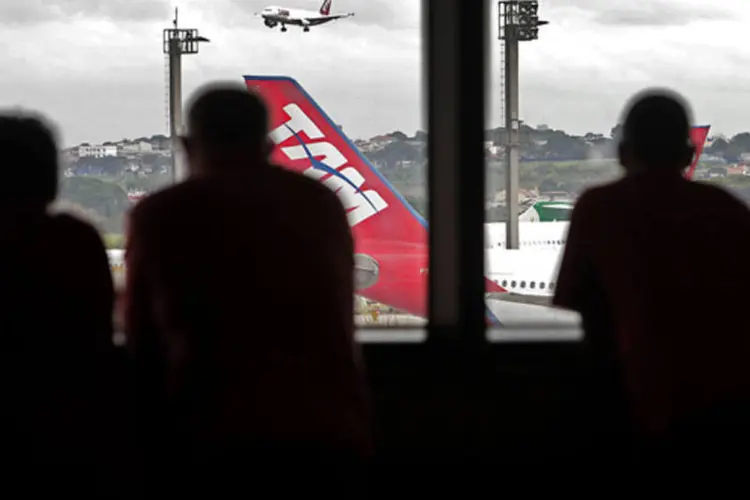 
	Passageiros assistem um avi&atilde;o pousando no aeroporto de Cumbica, em Garulhos
 (Dado Galdieri/Bloomberg)