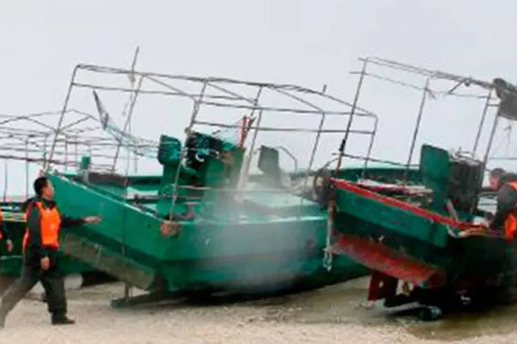 
	Equipes de emerg&ecirc;ncia tentam proteger barcos na ilha de Yongxing, na prov&iacute;ncia chinesa de Hainan: os barcos transportavam 88 pescadores&nbsp;
 (STR/AFP)