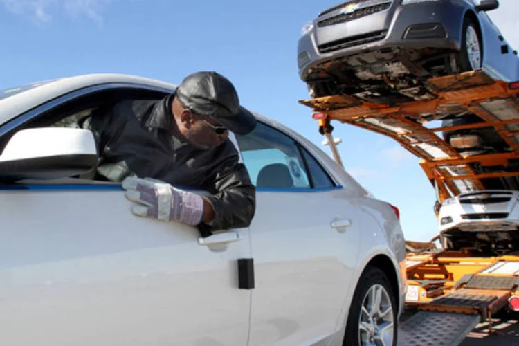 Motorista da General Motors (GM) carrega caminhão com o Chevrolet Malibu Eco 2013 para entregar para os revendedores nos Estados Unidos (Susan McSpadden/Getty Images)