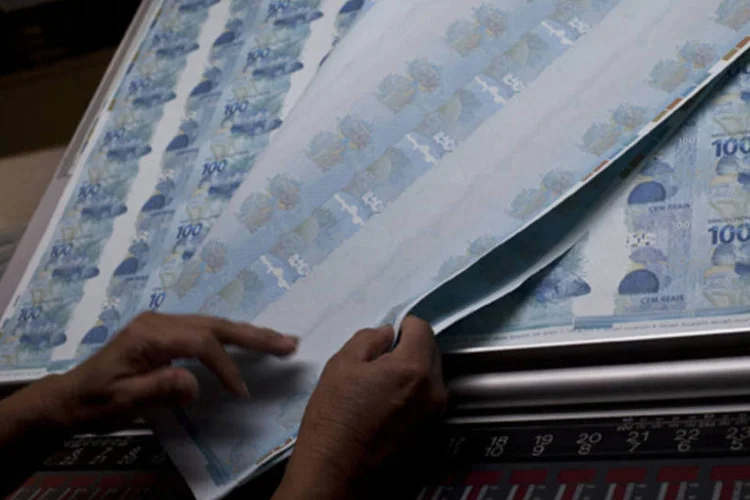 
	Trabalhador confere notas de R$ 100 produzidas na Casa da Moeda: segundo Credit Suisse, moeda brasileira vai saltar para US$ 2,15 em 12 meses
 (Dado Galdieri/Bloomberg)
