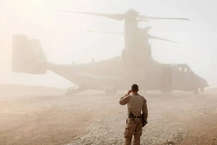 Fuzileiro naval dos Estados Unidos olha um helicóptero  na Base Operacional Avançada de Shukvani, no Afeganistão  (Scott Olson/Getty Images)