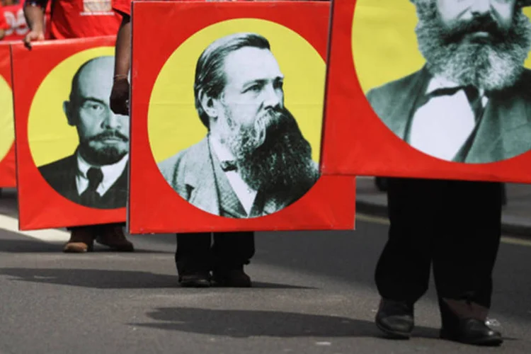 Manifestantes com imagens de pensadores do Comunismo em uma passeata em Londres, Inglaterra (Dan Kitwood/Getty Images)
