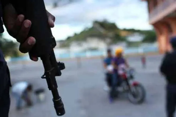 
	Policial segura arma em Tegucigalpa, Honduras: jornalismo se transformou em profiss&atilde;o de alto risco devido &agrave; viol&ecirc;ncia do crime organizado e &agrave; impunidade que prevalece no pa&iacute;s
 (Spencer Platt / Getty Images)
