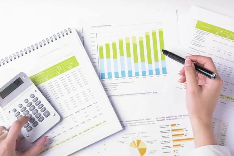 Pessoa analisando gráficos e fazendo contas (Thinkstock)