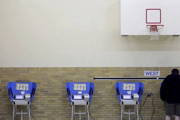 
	Um homem vota usando urna eletr&ocirc;nica em uma escola prim&aacute;ria em Bowling Green, Ohio: estima-se que no estado mais de 1,6 milh&atilde;o de pessoas votaram com anteced&ecirc;ncia&nbsp;
 (JD Pooley/Getty Images)