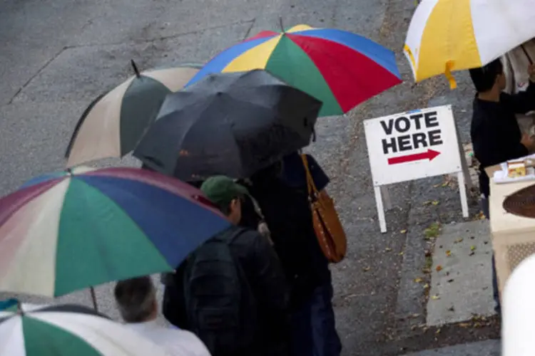 
	Eleitores esperam na fila sob chuva para votar em S&atilde;o Petersburgo, na Fl&oacute;rida, reconhecida como um campo de batalha muito disputado
 (Edward Linsmier/Getty Images)