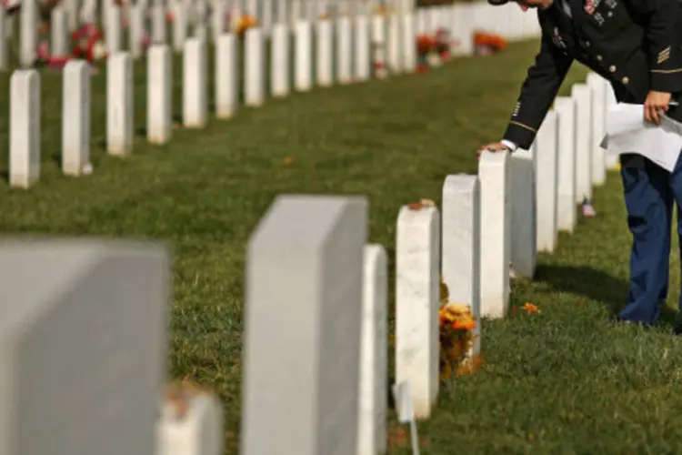 Membro do Exército americano toca lápide de companheiro morto, no Cemitério Nacional de Arlington, na Virgínia (Chip Somodevilla/Getty Images)