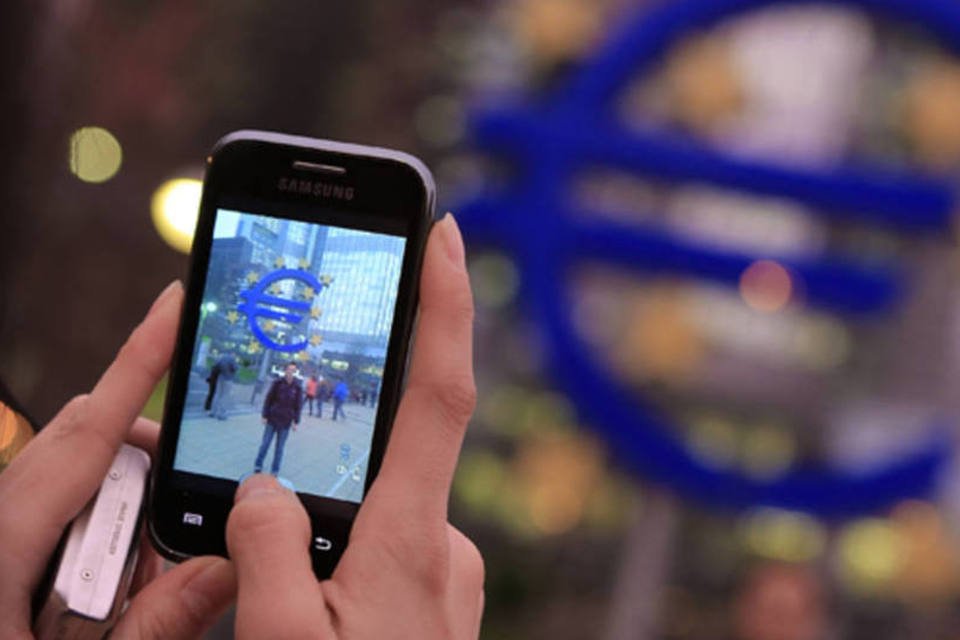 
	Turistas tiram fotos em frente ao s&iacute;mbolo do Euro na sede do Banco Central Europeu, em Frankfurt
 (Hannelore Foerster/Getty Images)