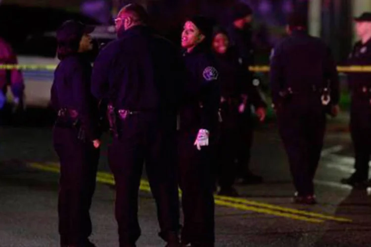 
	Policiais de Detroit conversam pr&oacute;ximo ao local do crime: a pol&iacute;cia est&aacute; interrogando mais de 20 testemunhas e acredita que v&aacute;rias pessoas foram respons&aacute;veis pelos disparos
 (Joshua Lott/AFP)