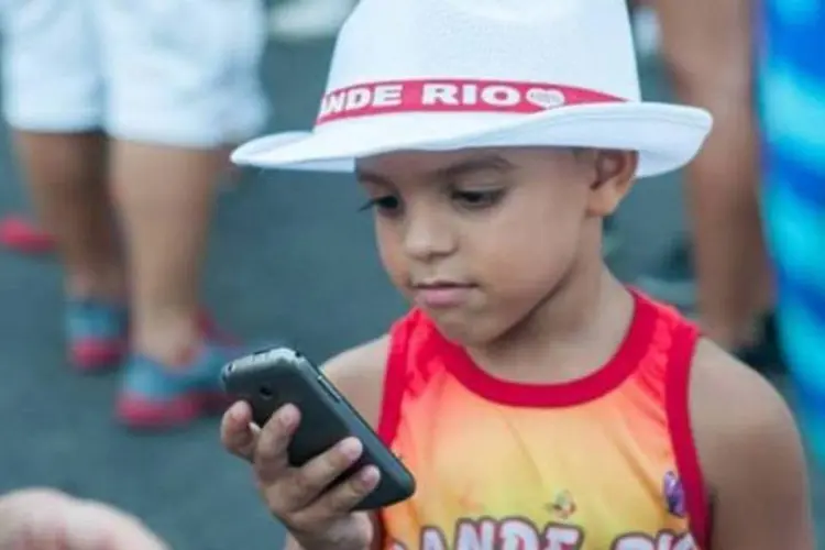 
	Pequeno torcedor da Grande Rio com celular: site permite que foli&otilde;es enviem fotos que ser&atilde;o mostradas durante o desfile
 (Grande Rio/Facebook)