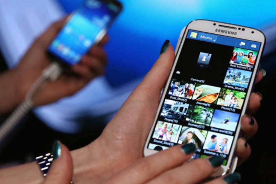 
	F&atilde;s testando o novo Samsung Galaxy S4: s&oacute;lidas vendas ocorreram mesmo ap&oacute;s problemas de abastecimento terem amea&ccedil;ado o lan&ccedil;amento de algumas operadoras nos EUA
 (Neilson Barnard/Getty Images)