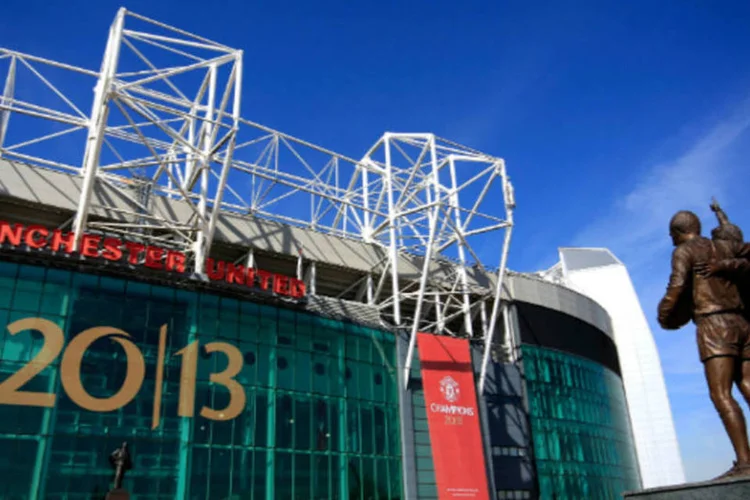 Fachada do estádio do Manchester United com cartaz comemorativo pela conquista do 20º título nacional na temporada (Thomas/Getty Images)