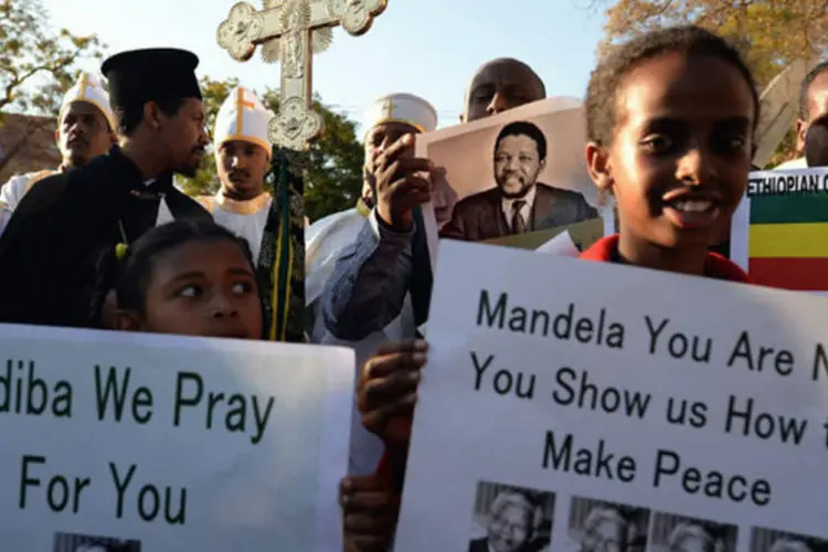 Em Pretória, crianças, adultos e representantes religiosos rezam juntos por Mandela (Jeff J Mitchell/Getty Images)