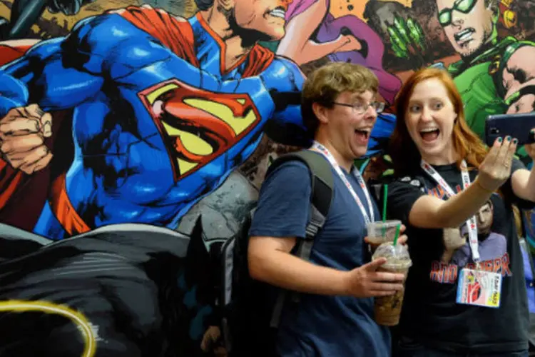 Visitantes tiram foto em frente a painel da DC na abertura da feira Comic-Con, em San Diego, na Califórnia ( Ethan Miller/Getty Images)