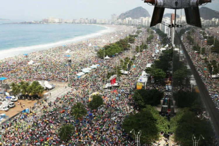 
	Homem fotografa multid&atilde;o em Copacabana para &uacute;ltima missa do papa Francisco na Jornada Mundial da Juventude, em 28 de julho de 2013
 (Mario Tama/Getty Images)