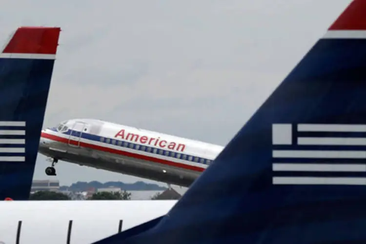 
	Jato da American Airlines decola atr&aacute;s de avi&otilde;es da US Airways no Aeroporto Nacional Ronald Reagan: no aeroporto, companhia formada controlaria 69% de vagas para pousos e decolagens
 (Win McNamee/Getty Images)