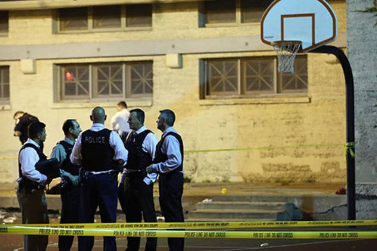 Policiais em uma quadra do Cornell Square Park, onde um conflito entre gangues deixou ao menos 13 pessoas feridas, em Chicago (Scott Olson/Getty Images)