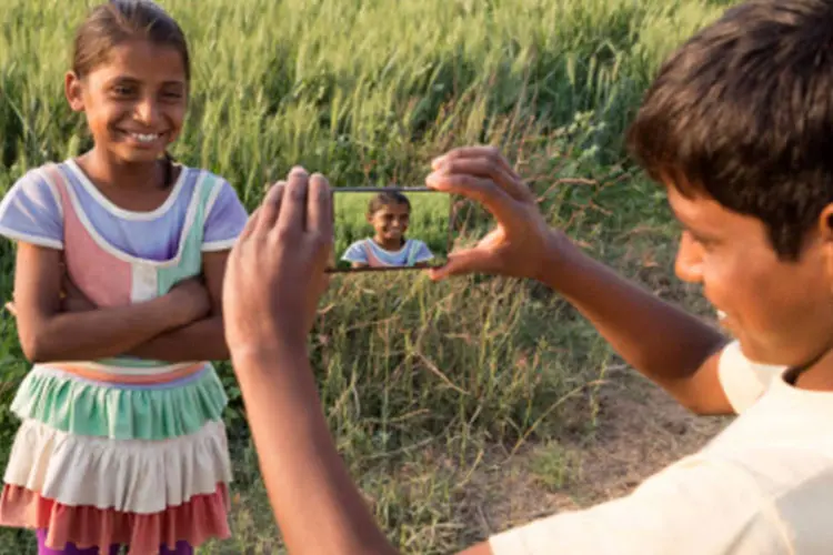 Crianças com smartphone na Índia: ideia é tentar melhorar estatísticas de países como Etiópia, onde a penetração móvel é de 20%, ou mesmo na Índia, que ainda tem penetração de 28% (Adrian Pope/Getty Images)