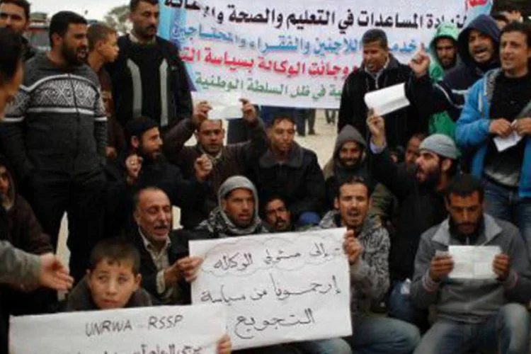 Palestinos se reúnem em frente à sede da UNRWA, em Gaza, em 26 de janeiro de 2014 (Said Khatib/AFP)