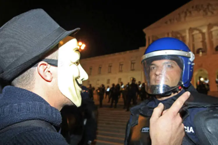 
	Manifestante discute com policial durante protesto em frente ao Parlamento de Portugal: a emigra&ccedil;&atilde;o de pessoas jovens poder&aacute; ter efeito grave no futuro econ&ocirc;mico do pa&iacute;s
 (José Manuel Ribeiro/Reuters)