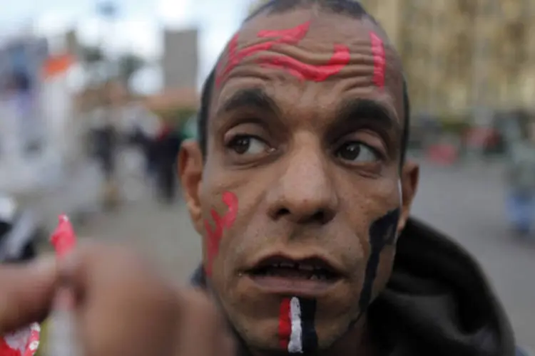 Um manifestante é retratado com uma bandeira do Egito sendo pintada em seu rosto e a frase "Saia, Mursi" na Praça Tahrir  (Amr Abdallah Dalsh/Reuters)