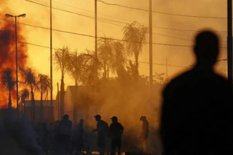 Policial protege supermercado na cidade de San Fernando, próxima a Buenos Aires, durante onde de saques em 21 de dezembro de 2012 (Marcos Brindicci / Reuters)