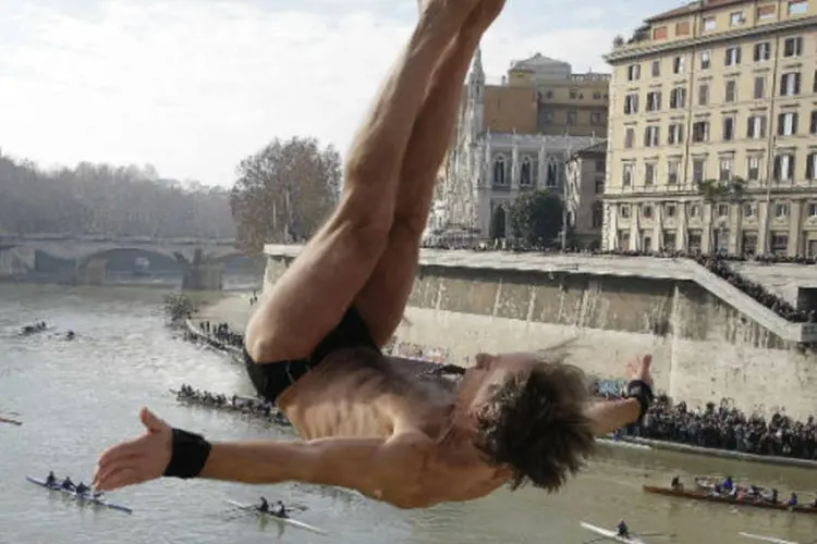 
	Homem pula da ponte Cavour, no rio Tibre, na It&aacute;lia, para comemorar o ano novo
 (Tony Gentile / Reuters)