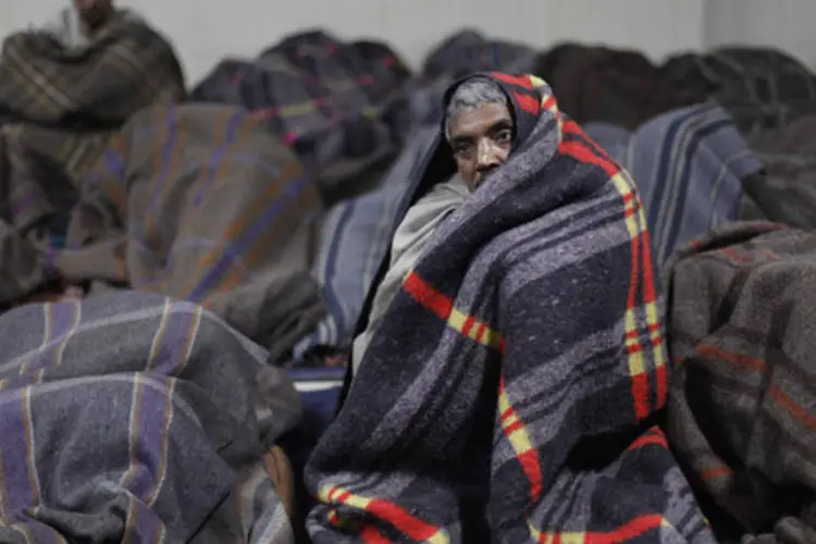 Sem-teto com cobertores são vistos em um abrigo gerido por uma ONG nos bairros antigos de Délhi: a onda de frio que castiga o norte de Índia já tirou 126 vidas humanas (Mansi Thapliyal/Reuters)