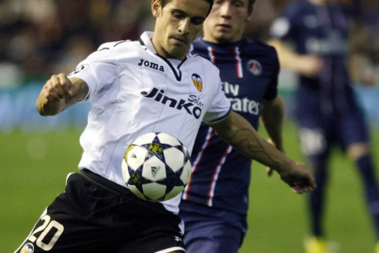 
	Ricardo Costa (e), do Valencia, tenta controlar a bola enquanto &eacute; marcado por Clement Chantome, do Paris Saint Germain: a equipe francesa venceu o Valencia por 2 a 1
 (Heino Kalis/AFP)