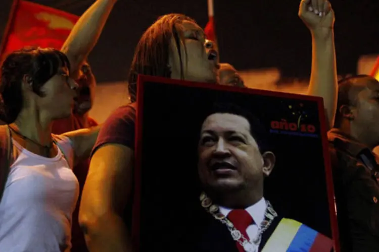 Apoiadores do presidente Hugo Chávez reagem ao anuncio de sua morte no lado de fora do hospital onde estava sendo tratado, em Caracas (Carlos Garcia Rawlins/Reuters)