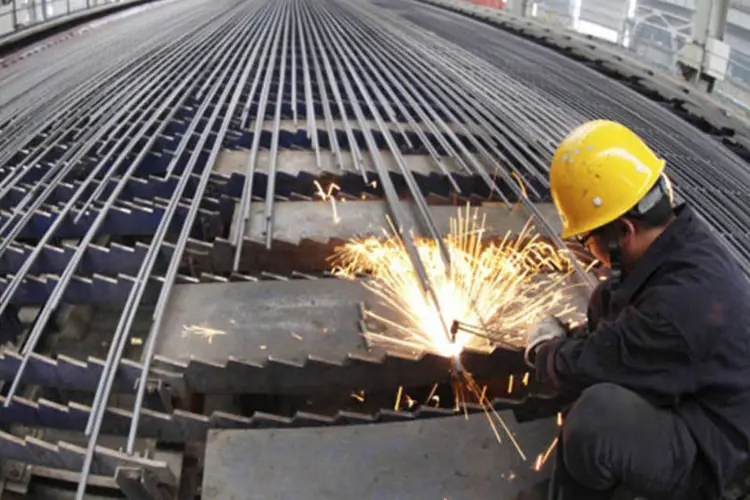 
	Trabalhador corta barras em f&aacute;brica de a&ccedil;o na prov&iacute;ncia de Jiangsu, China: lucros do setor ca&iacute;ram 98% no ano passado
 (China Daily/Reuters)