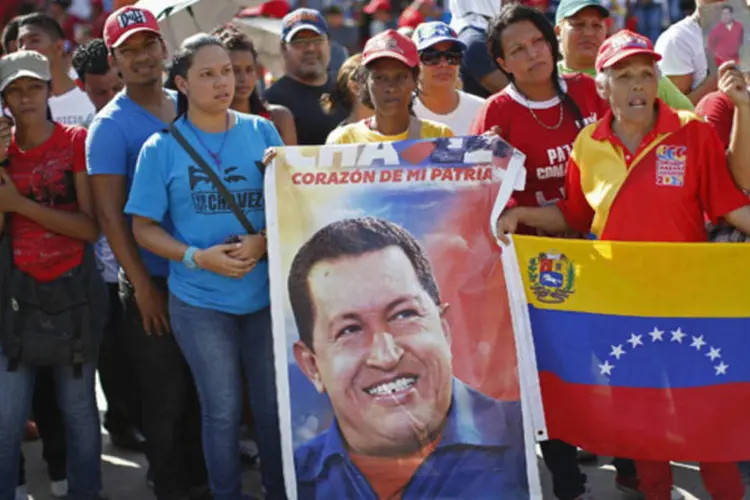 Simpatizantes do presidente venezuelano, Hugo Chávez, observam a chegada do caixão com o corpo do mandatário na Academia Militar, em Caracas, na Venezuela (Jorge Silva/Reuters)