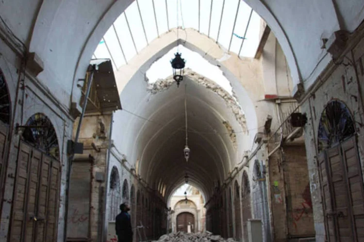 Morador da cidade síria de Deir al-Zor observa o que opositores afirmam ser estragos causados por bombardeio de forças leais ao regime (Reuters)