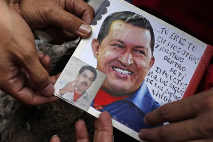 
	Eleitor cola foto de Maduro em uma de Ch&aacute;vez, como forma de demonstrar o seu apoio ao candidato: segundo o argentino, o objetivo &eacute; defender os processos democr&aacute;ticos na regi&atilde;o
 (Tomas Bravo/Reuters)