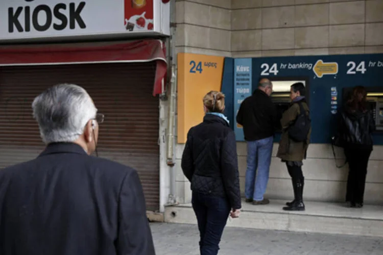 
	Pessoas aguardam em fila para usar um caixa-eletr&ocirc;nico: ultimato foi dado no momento em que l&iacute;deres realizam discuss&otilde;es sobre um &quot;Plano B&quot; para tentar levantar &euro; 5,8 bilh&otilde;es exigidos
 (Yorgos Karahalis/Reuters)
