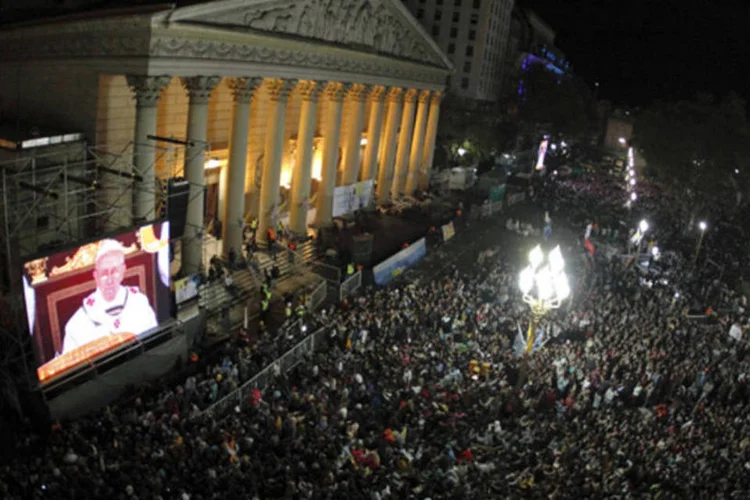 Fiéis assistem à missa inaugural de papa Francisco em uma tela gigante ao lado da Catedral Metropolitana, em Buenos Aires (Enrique Marcarian/Reuters)