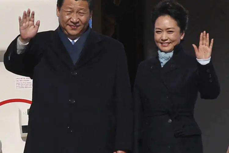 Presidente da China, Xi Jinping, e a primeira-dama, Peng Liyuan, acenam enquanto desembarcam de avião na chegada a Moscou (Maxim Shemetov/Reuters)