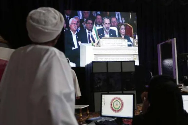 
	Integrantes da m&iacute;dia assistem ao l&iacute;der da Coaliz&atilde;o Nacional S&iacute;ria, Mouaz al-Khatib, durante discurso ao vivo na abertura da C&uacute;pula da Liga &Aacute;rabe
 (Ahmed Jadallah/Reuters)