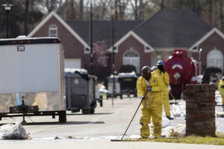 Equipes de emergência trabalham na limpeza de um derramamento de petróleo em frente a casas evacuadas na Starlite Road, em Mayflower (Jacob Slaton/Reuters)