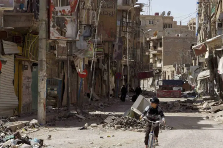 Menino anda de bicicleta na cidade de Deir al-Zor, na Síria (Khalil Ashawi/Reuters)