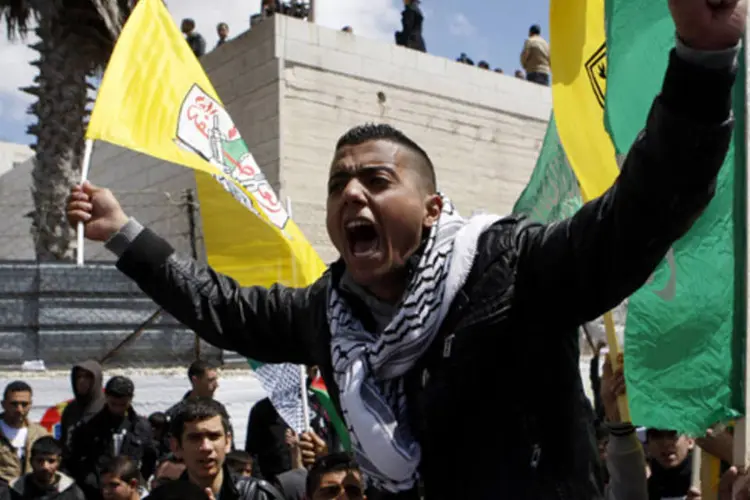 Palestino com a bandeira do Fatah grita durante funeral de Maysara Abu Hamdeya na cidade de Hebron, na Cisjordânia (Mussa Qawasma/Reuters)