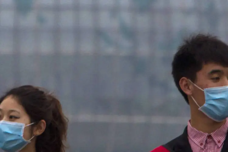 Casal usando máscaras caminha perto do rio Huangpu, no centro de Xangai, na China (Aly Song/Reuters)