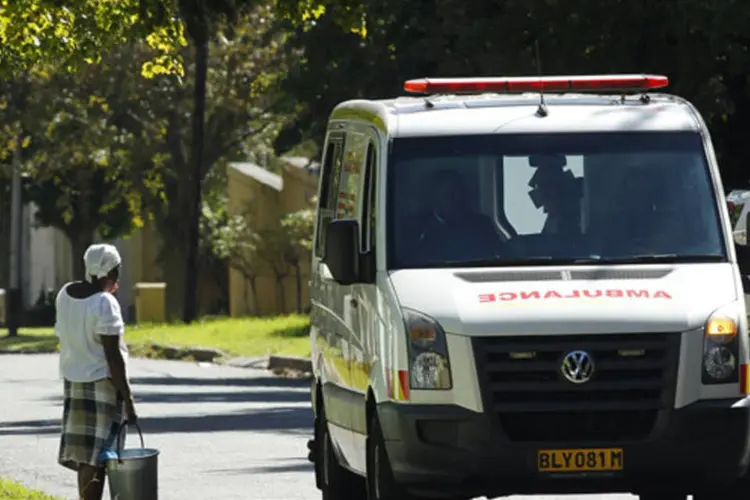 Mulher observa ambulância que acredita-se estar transportando Nelson Mandela até sua casa em Houghton, África do Sul (Siphiwe Sibeko/Reuters)